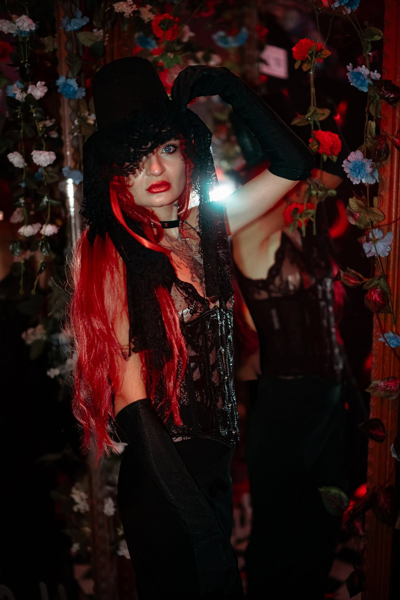 A guest with red hair, a black top hat and a lace costume