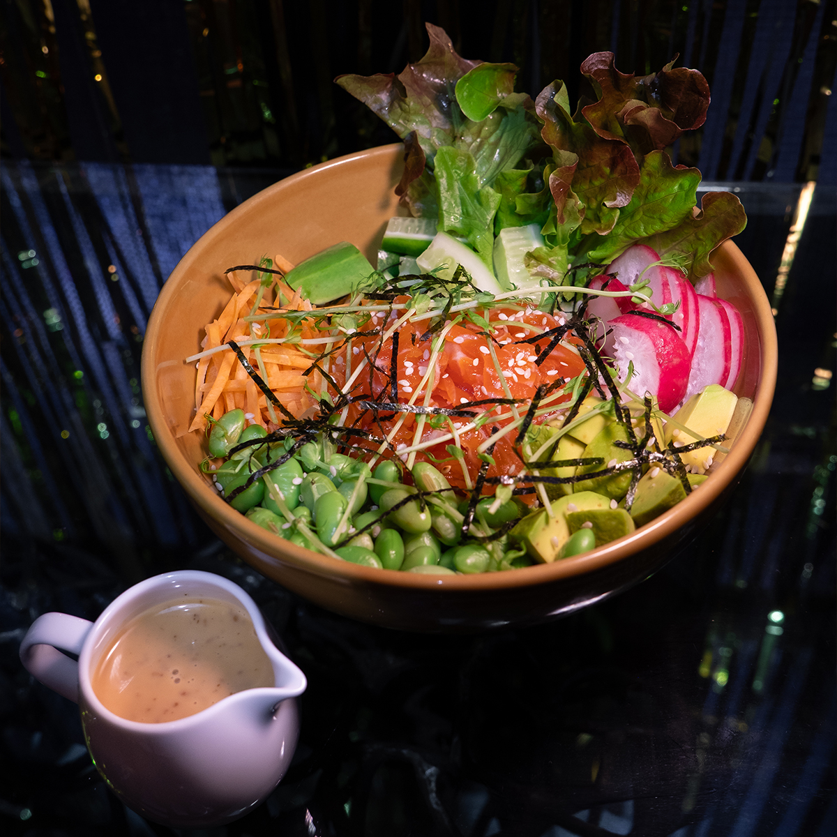 Salted salmon poke bowl with rice, avocado and fresh vegetables at MESTO